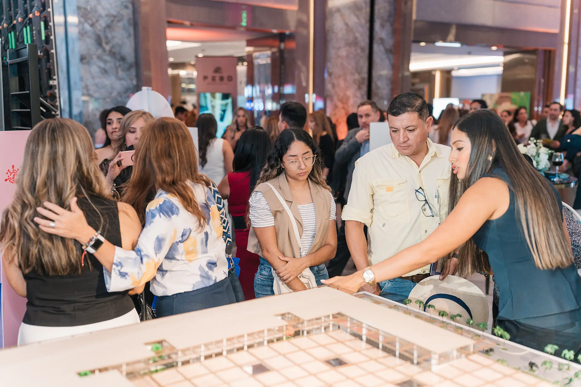 Asistentes observan una maqueta de un proyecto inmobiliario premium